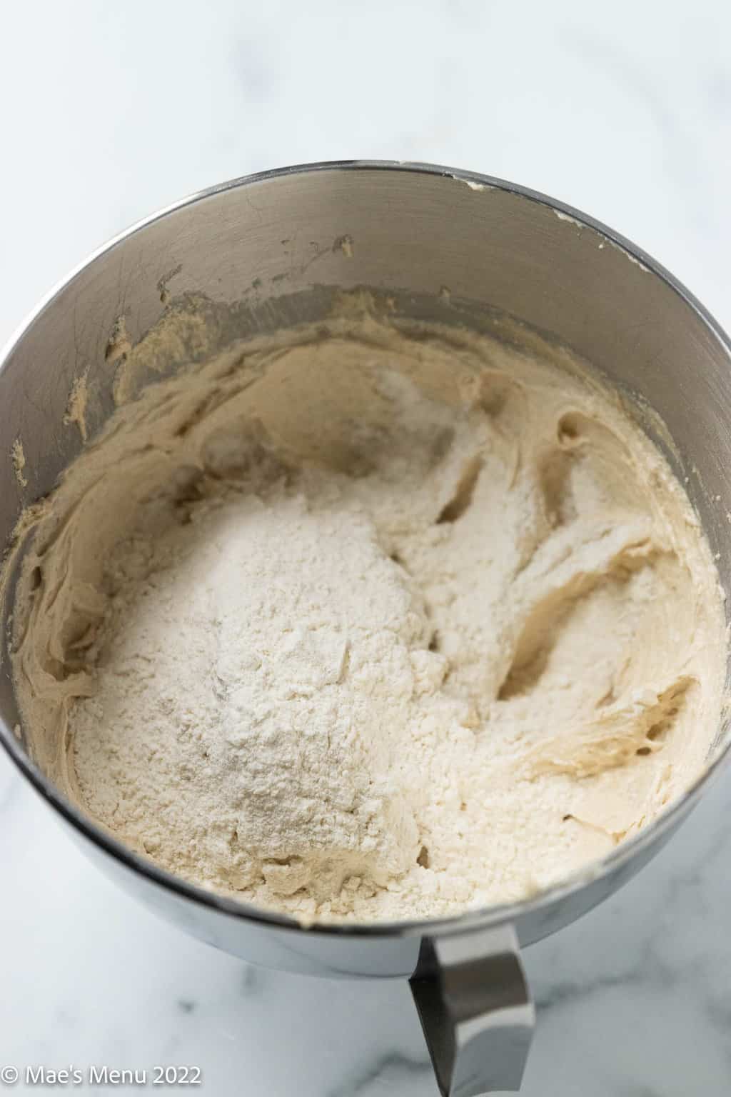 A mixing bowl with creamed butter, sugar, and flour.