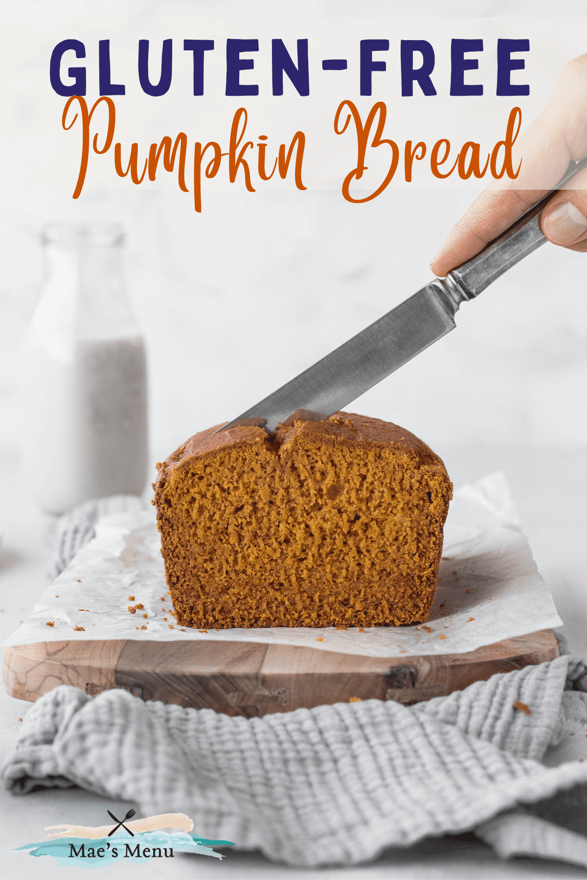 Pinterest pin with hand holding a silver knife and cutting into a fresh loaf of pumpkin bread.