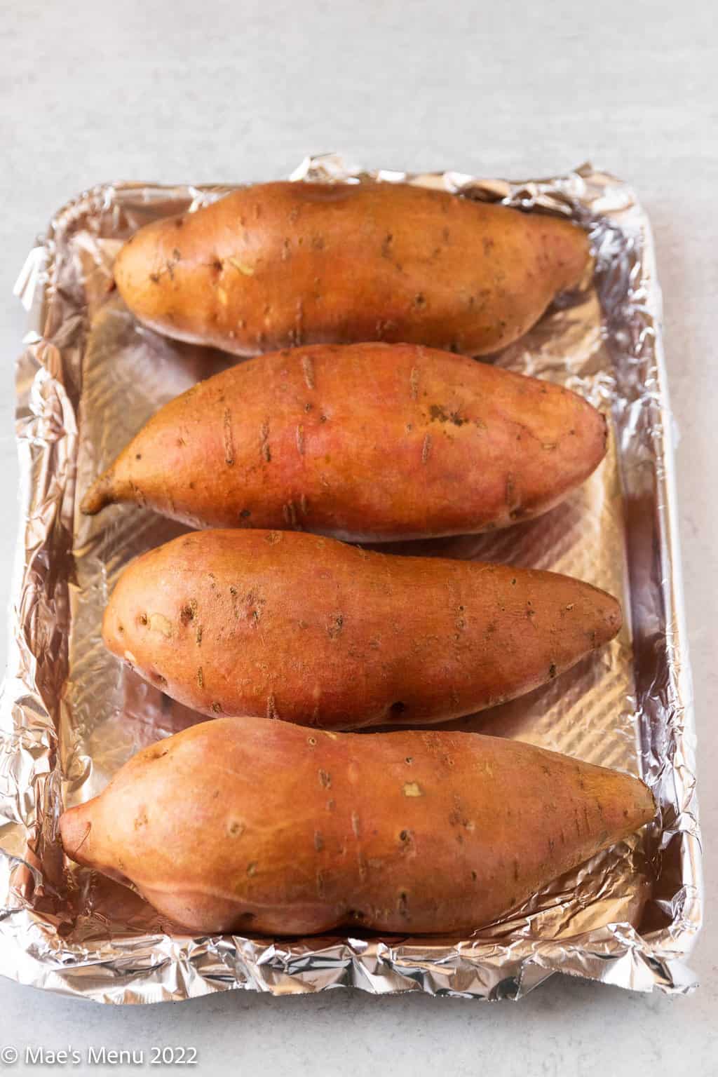 A foil lined baking sheet of sweet potatoes.