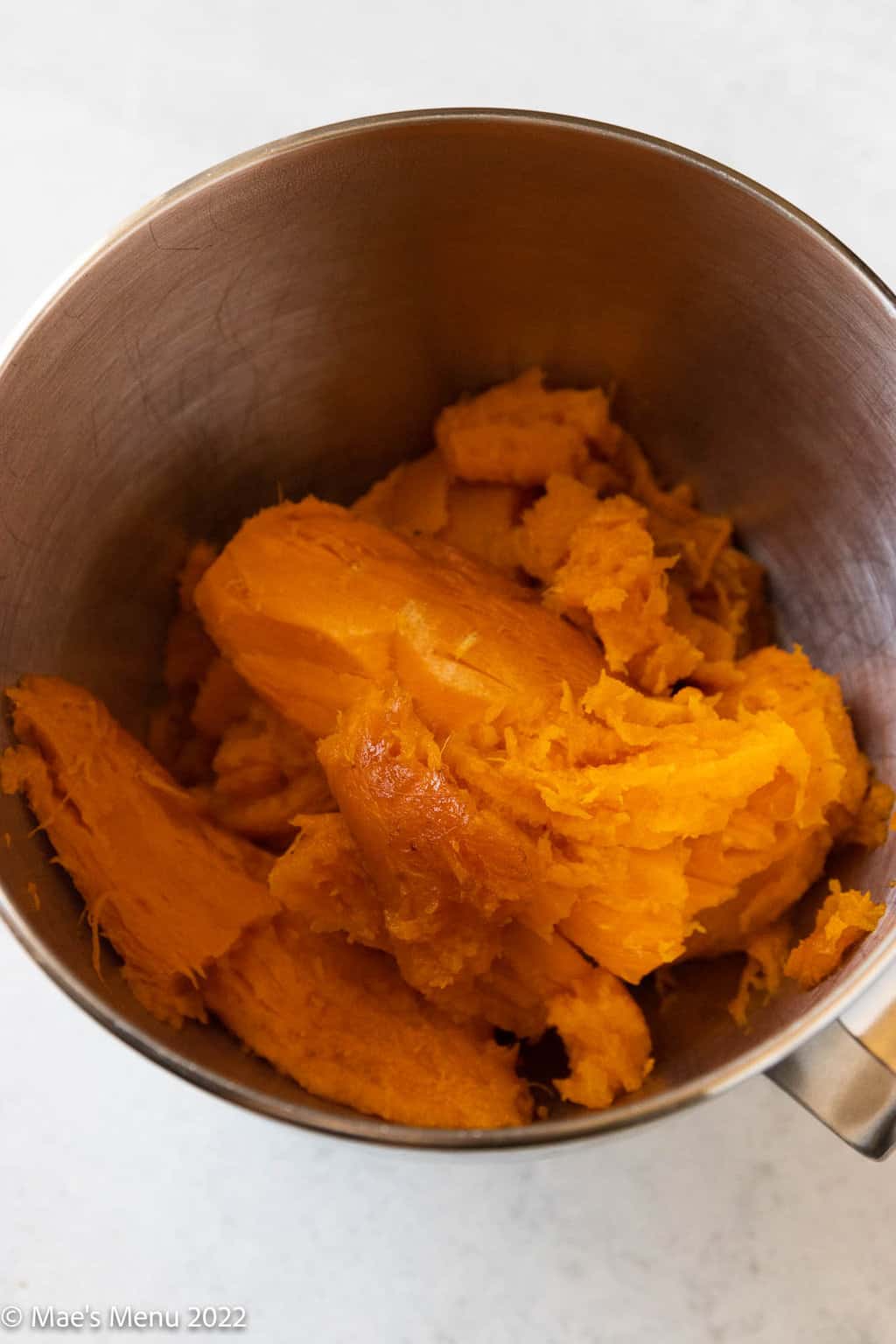 Baked sweet potato pulp in the bowl of a stand mixer.