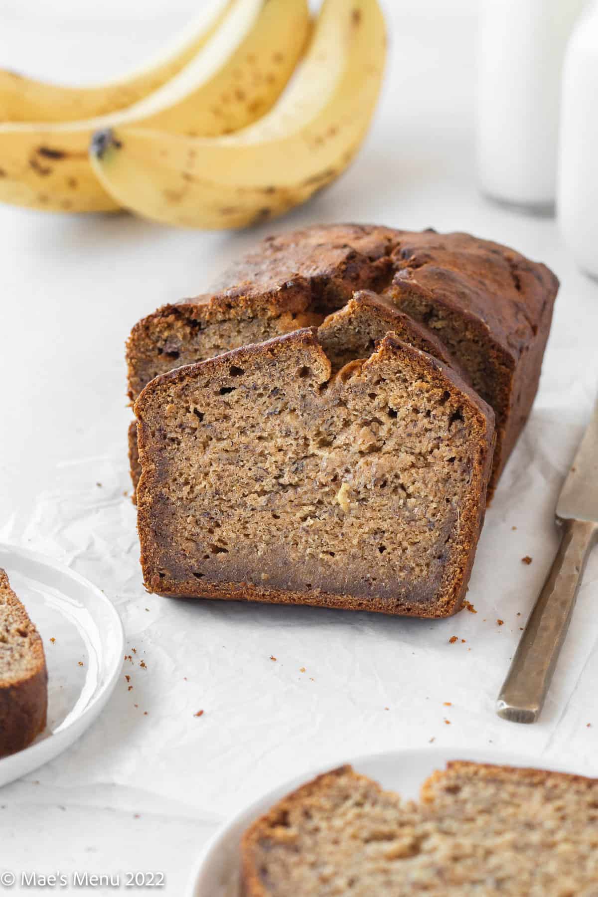 A side shot of a sliced loaf of dairy free banana bread.
