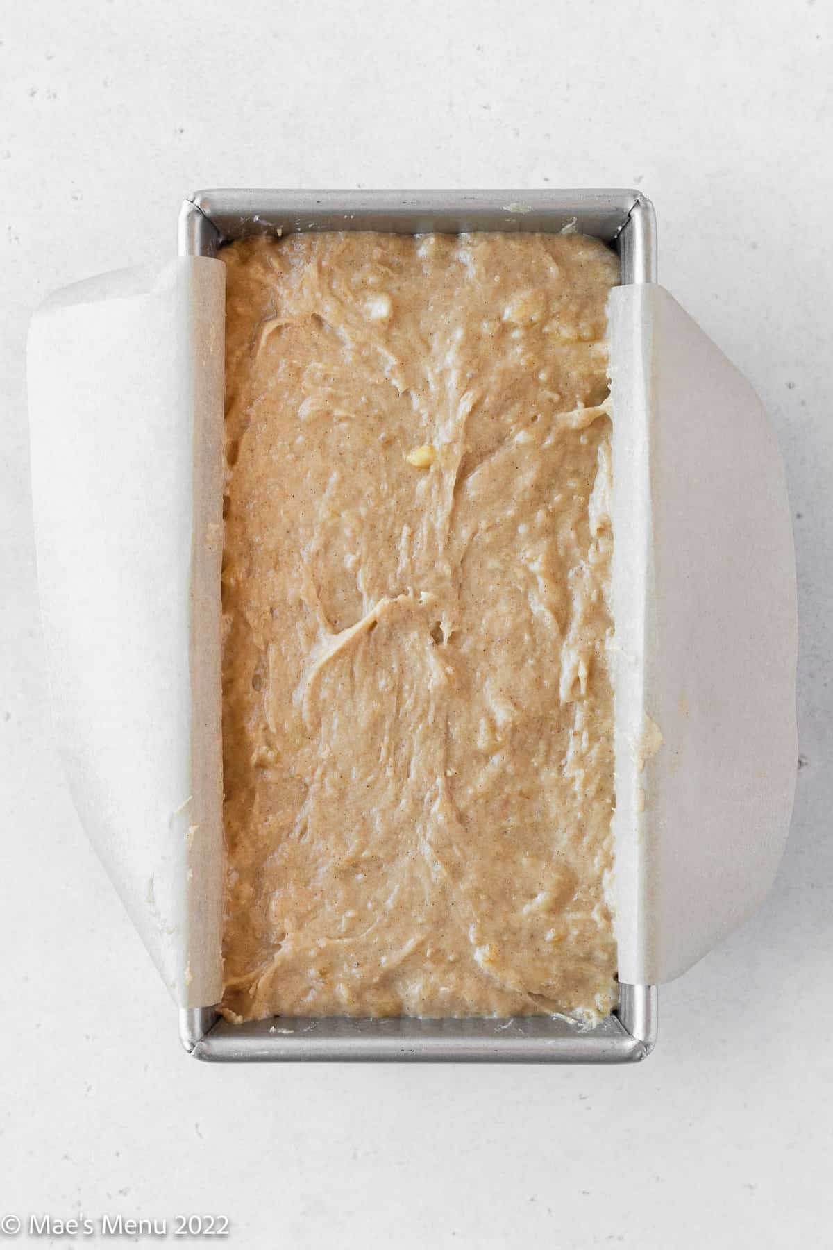 A metal loaf pan filled with dairy free banana bread dough.