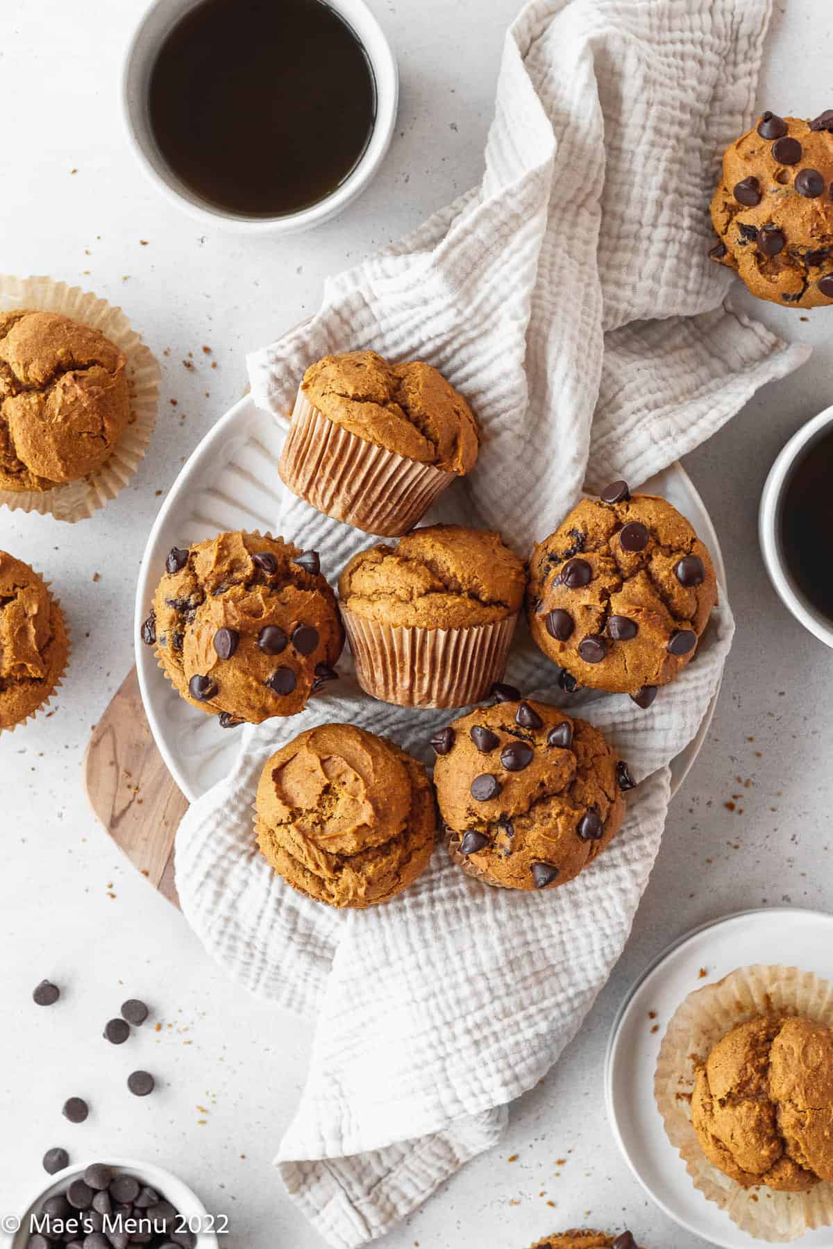An overhead shot of gluten free pumpkin muffins in a small bowl with a white towel.
