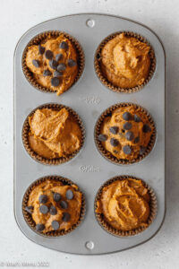 Gluten-free pumpkin muffins in a muffin pan before baking.