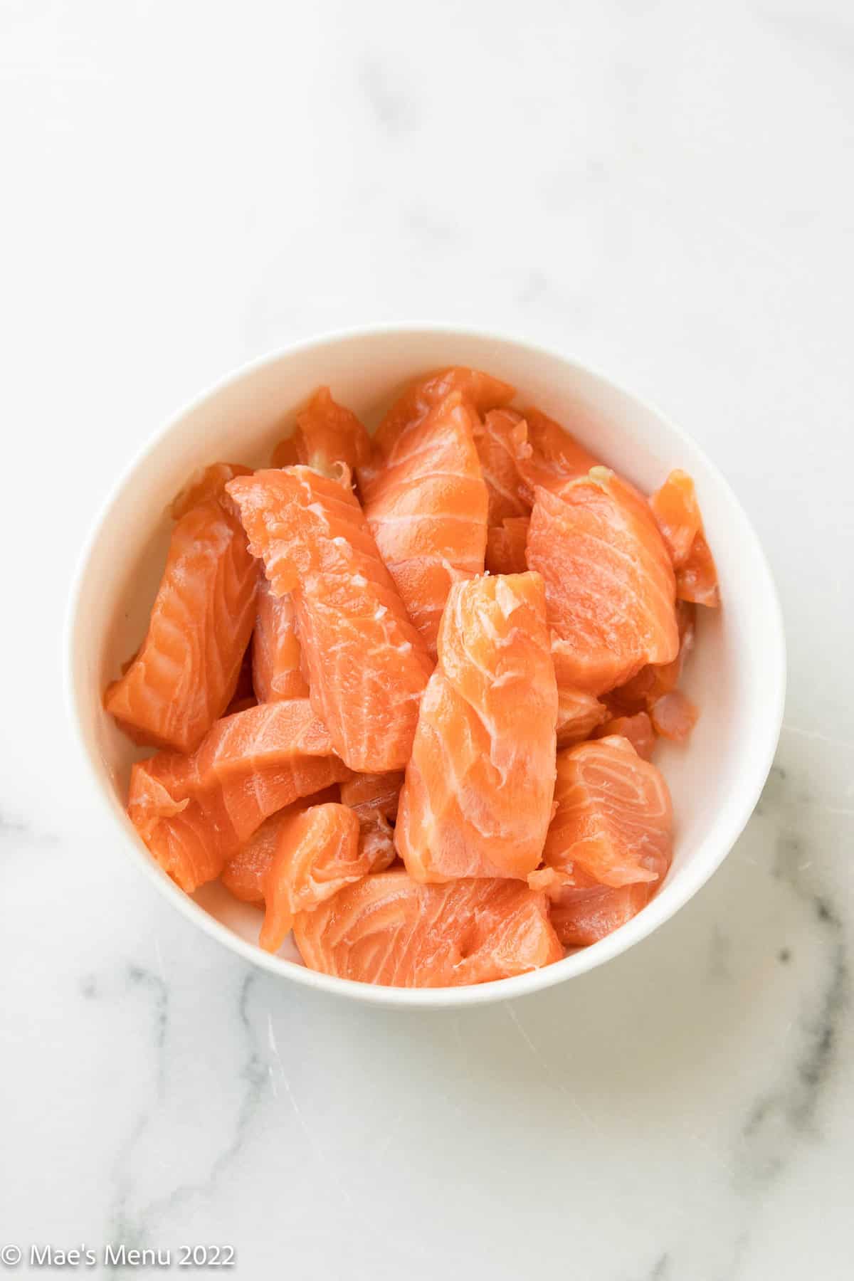 A small white dish of sliced salmon.