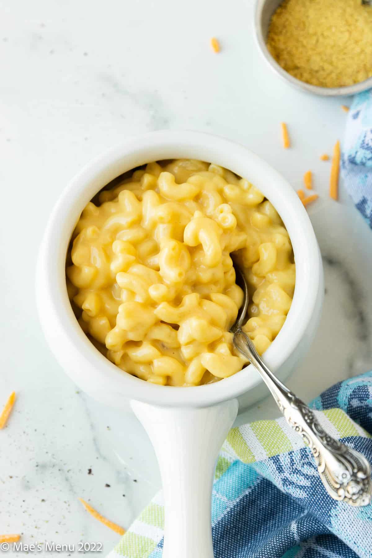 small white butter warmer filled with lactose free macaroni and cheese.