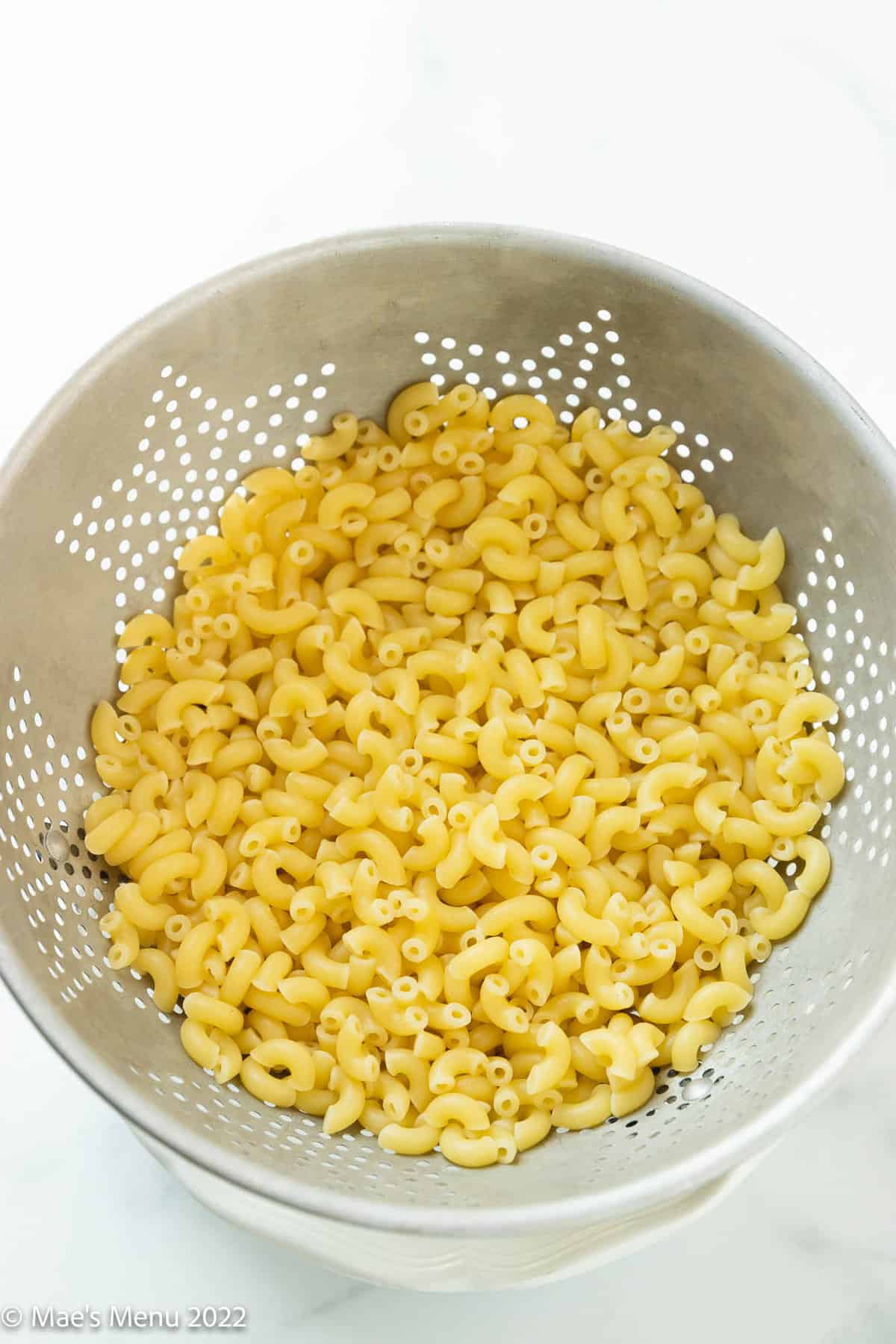 draining elbow macaroni in a colander.