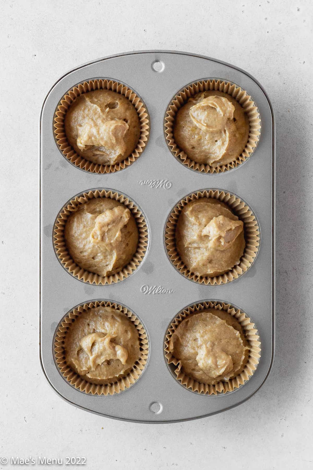 overhead shot of dairy-free muffin batter in a prepared muffin tin before baking.