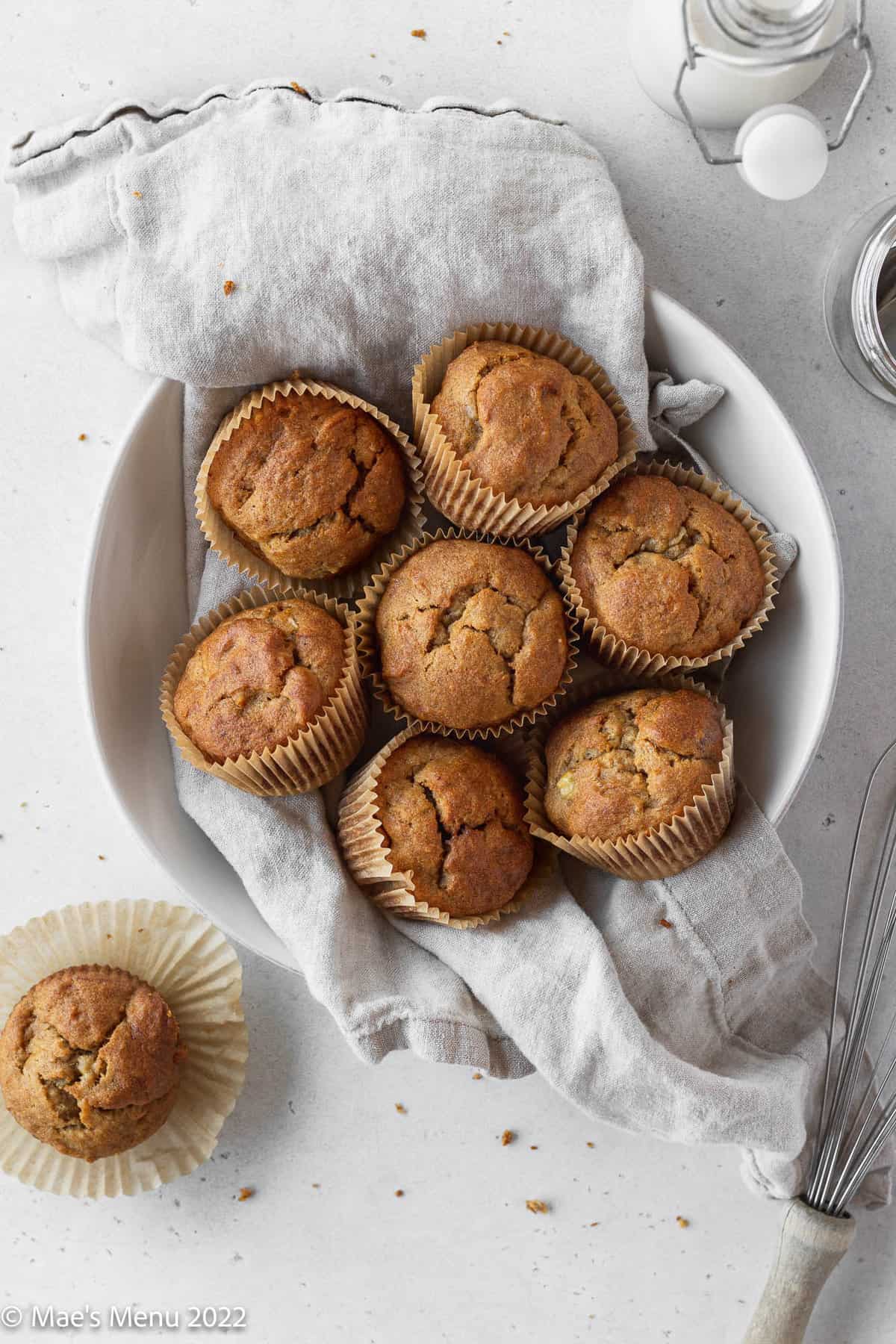 overhead shot of a white bowl lined with a white linen and filled with baked dairy-free banana muffins.