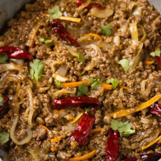 A large skillet of ground beef stir fry with Sichuan chiles.