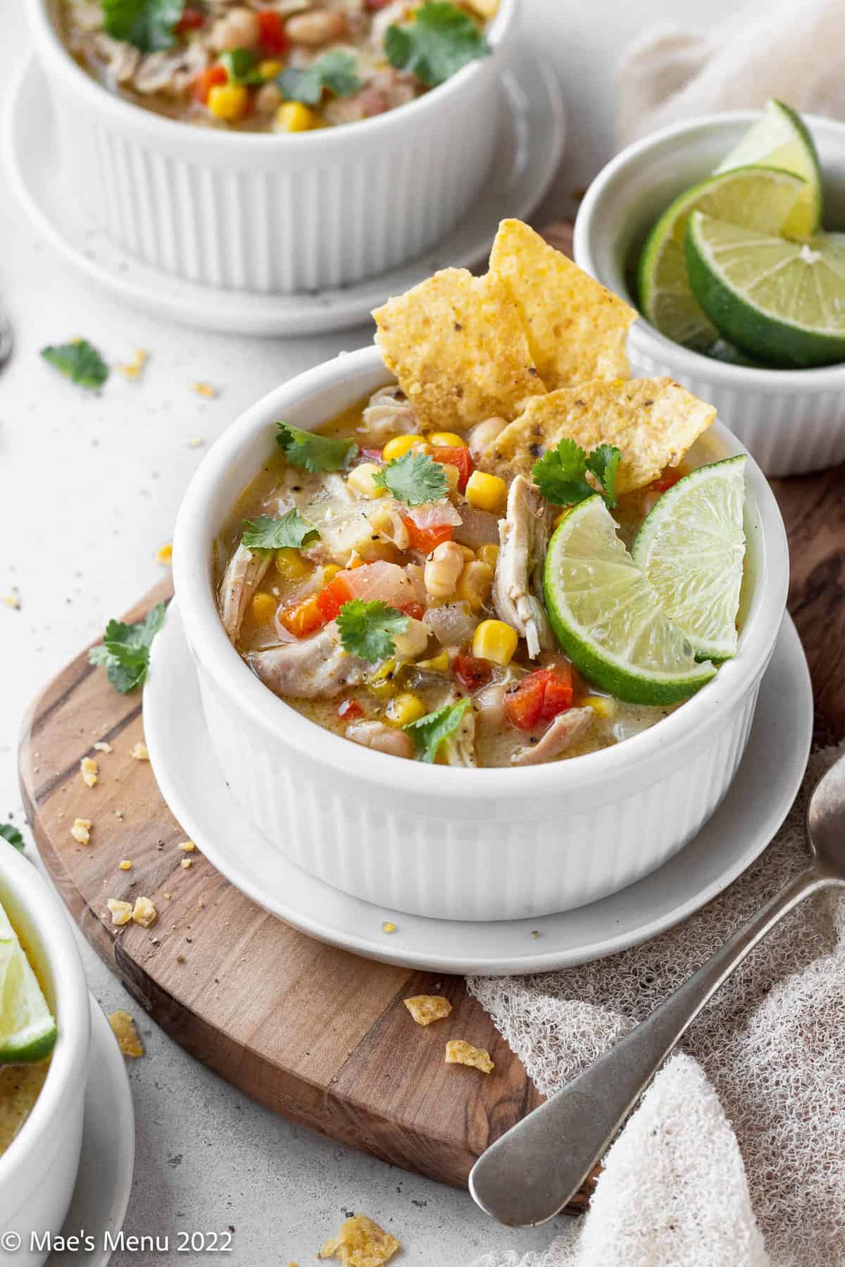 A warm bowl of creamy white chicken tortilla soup with tortilla chips and lime.