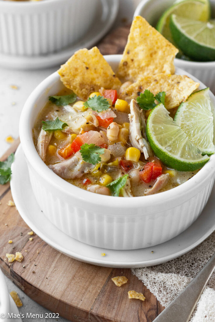 An up-close shot of a white bowl of creamy white chicken tortilla soup.