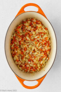 Sauteed onions, peppers, garlic, and spices in a ceramic pot.