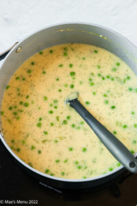 A large pot of the cheese soup with dill and green peas.