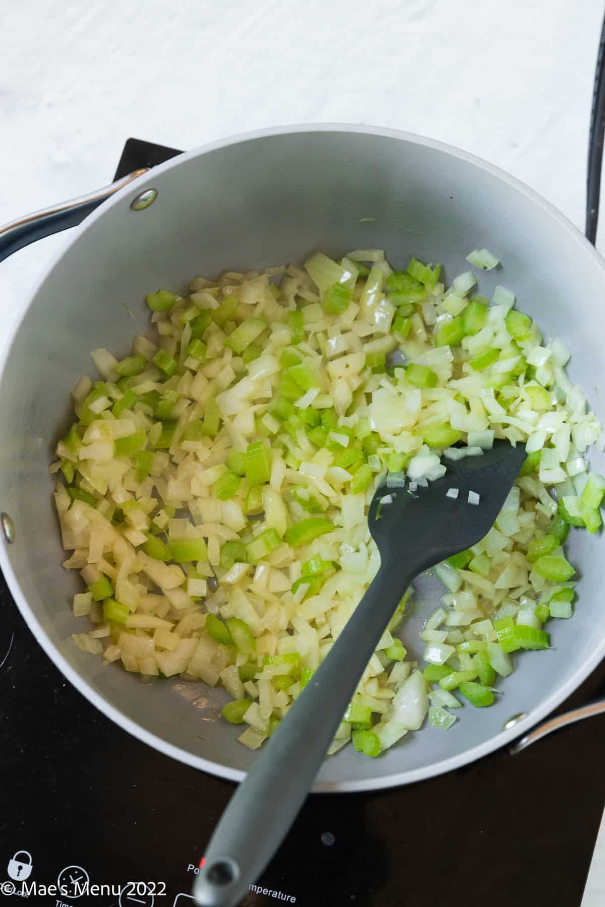 Sauteing onions and celery in a large pot.