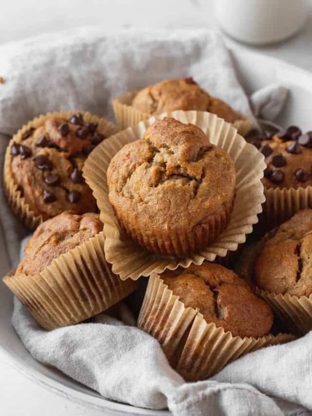white serving bowl filled with half dairy-free banana muffins and half dairy-free banana chocolate chip muffins.