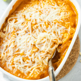 A white bowl of dairy-free buffalo chicken dip with a spoon in it.