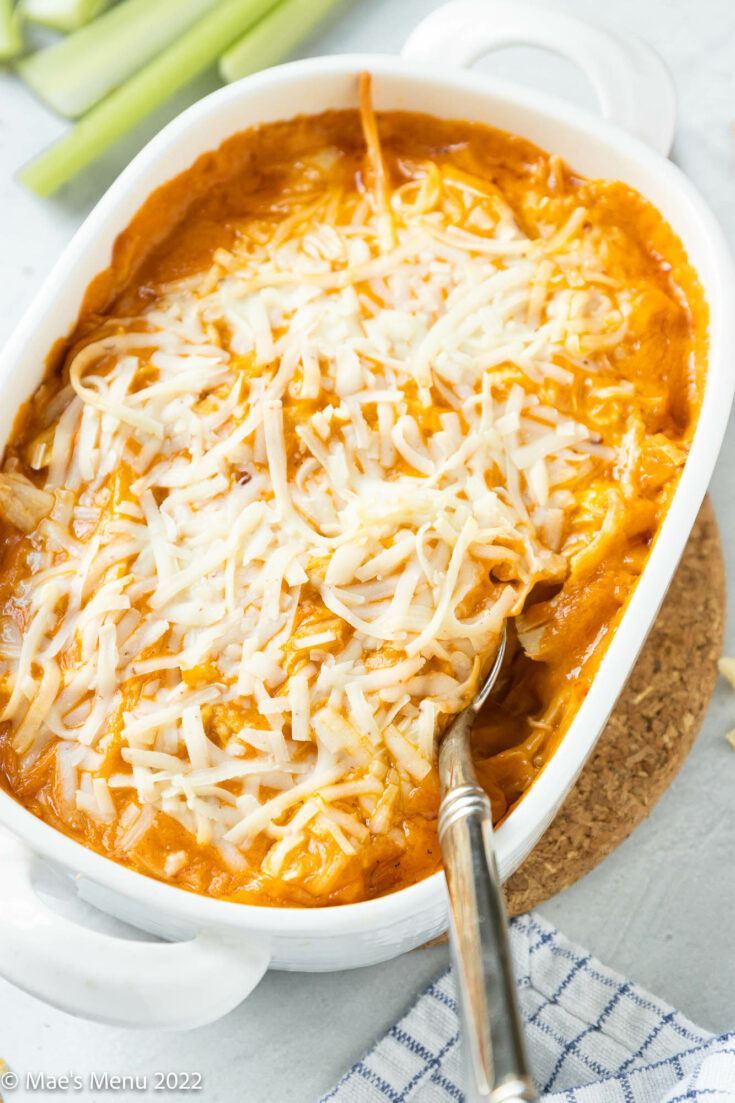A white bowl of dairy-free buffalo chicken dip with a spoon in it.