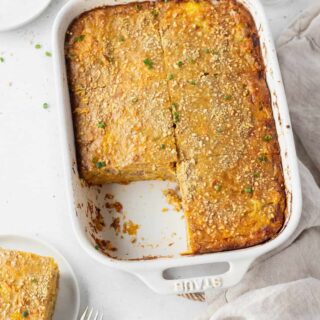 A white pan of dairy-free breakfast casserole with a slice taken out of it.