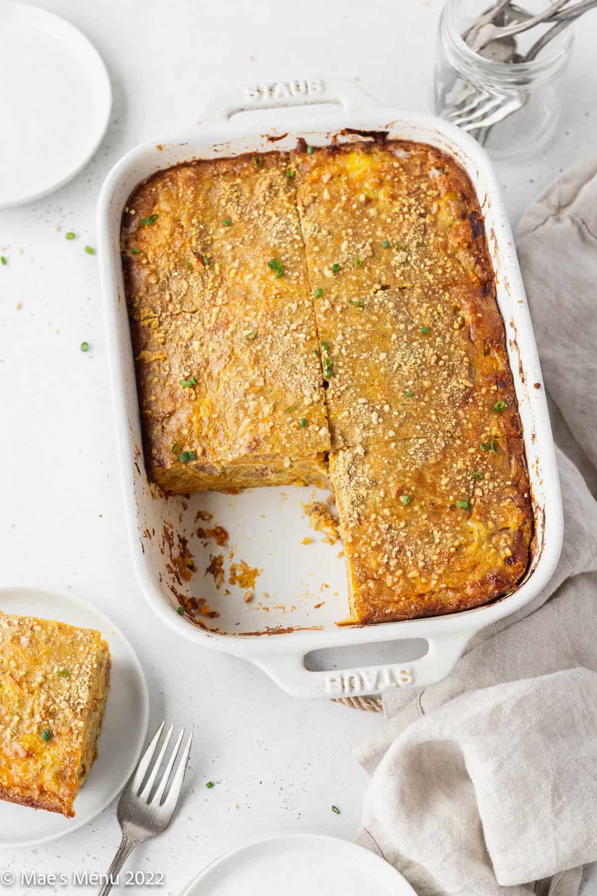 A white pan of dairy-free breakfast casserole with a slice taken out of it.