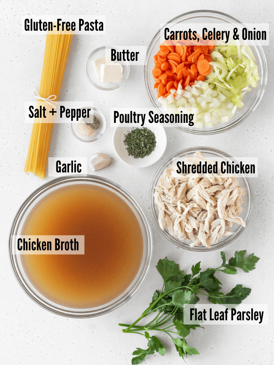 ingredients for making gluten-free chicken noodle soup measured out on a table with text overlay.