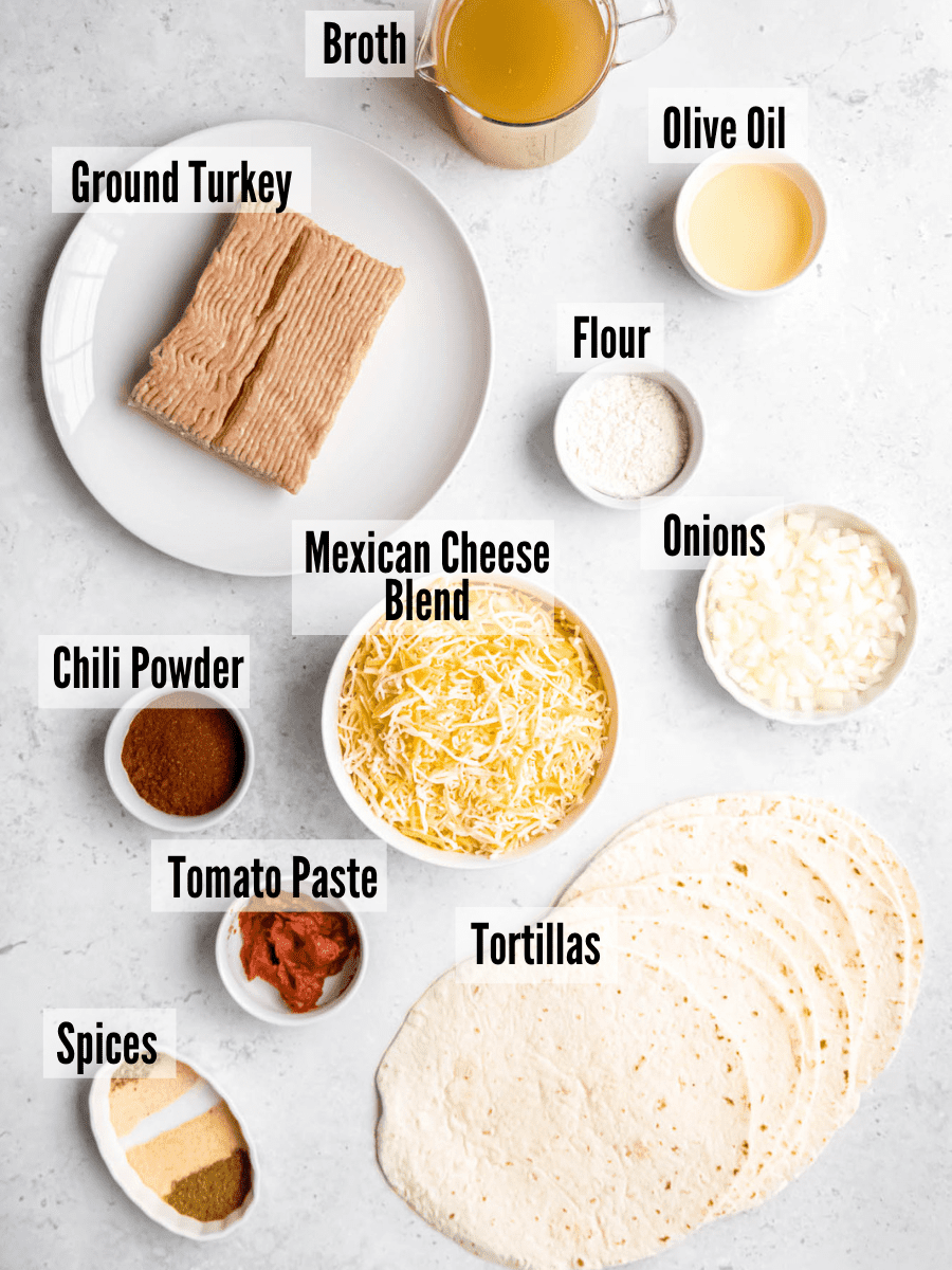 Ground turkey enchilada ingredients: ground turkey, broth, spices, tortillas, Mexican cheese blend, chili powder, flour, onion, tomato paste, and olive oil.