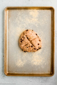 The ball of walnut dough scored on a prepared baking sheet.