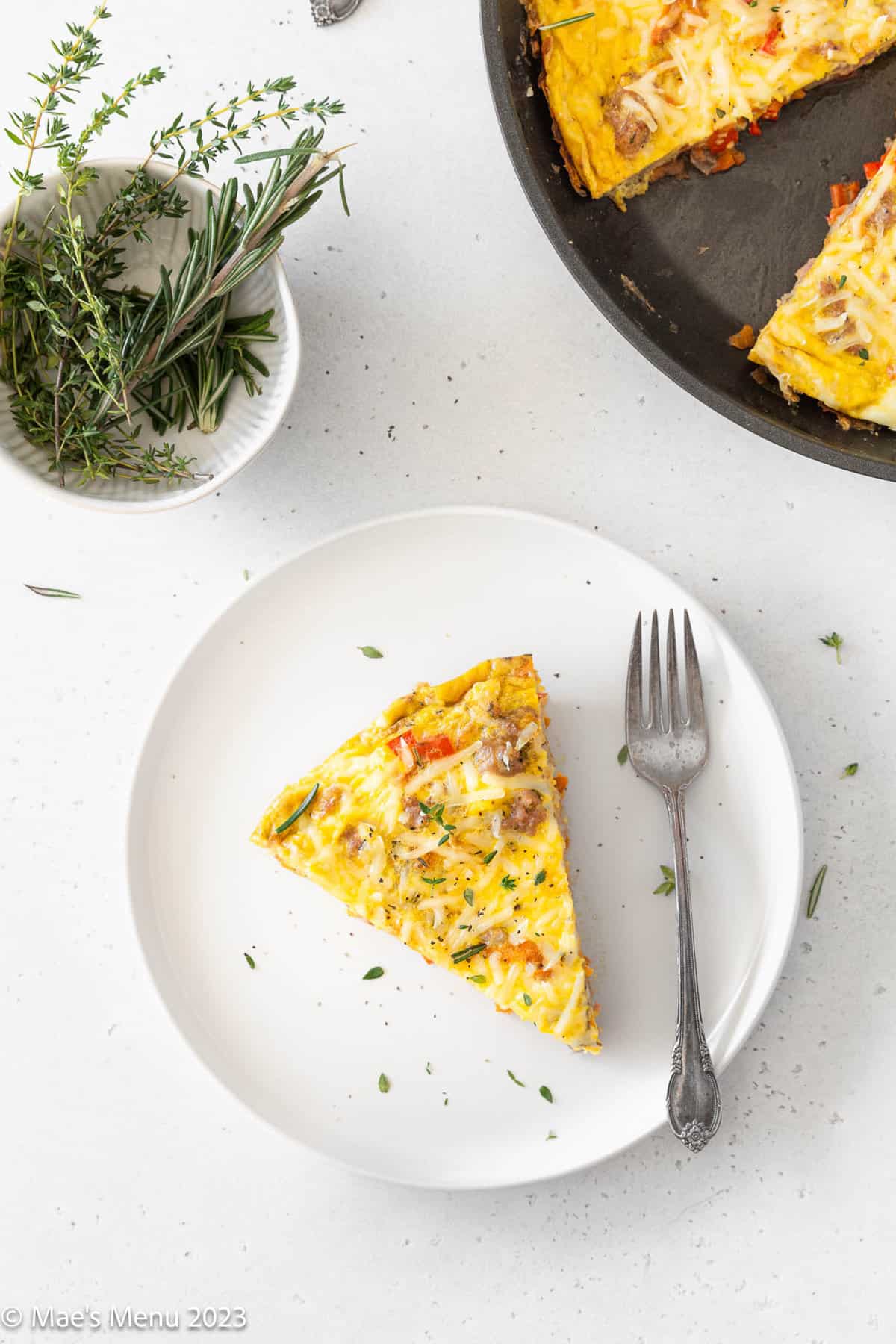 An overhead shot of a white plate with frittata on it.