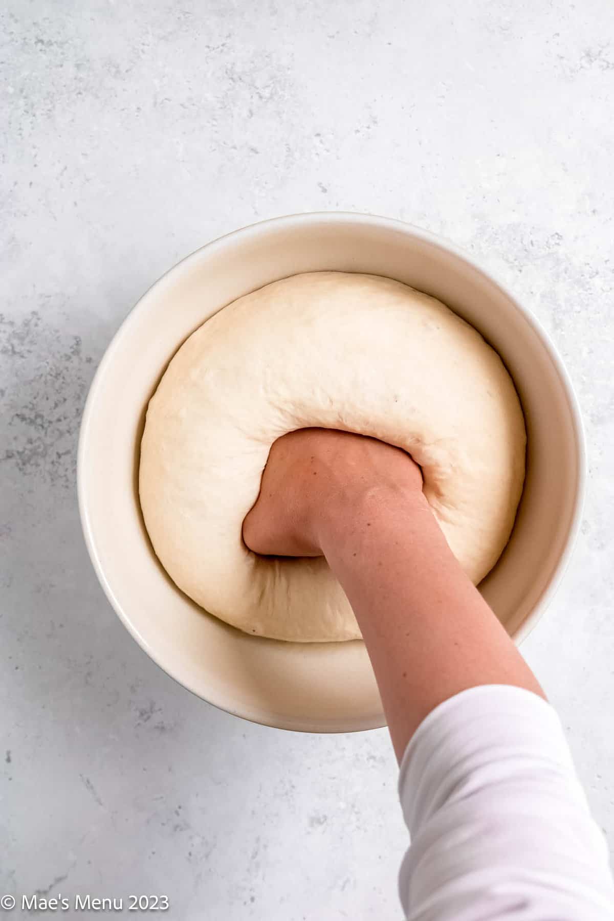 Punching the loaf of bread down.