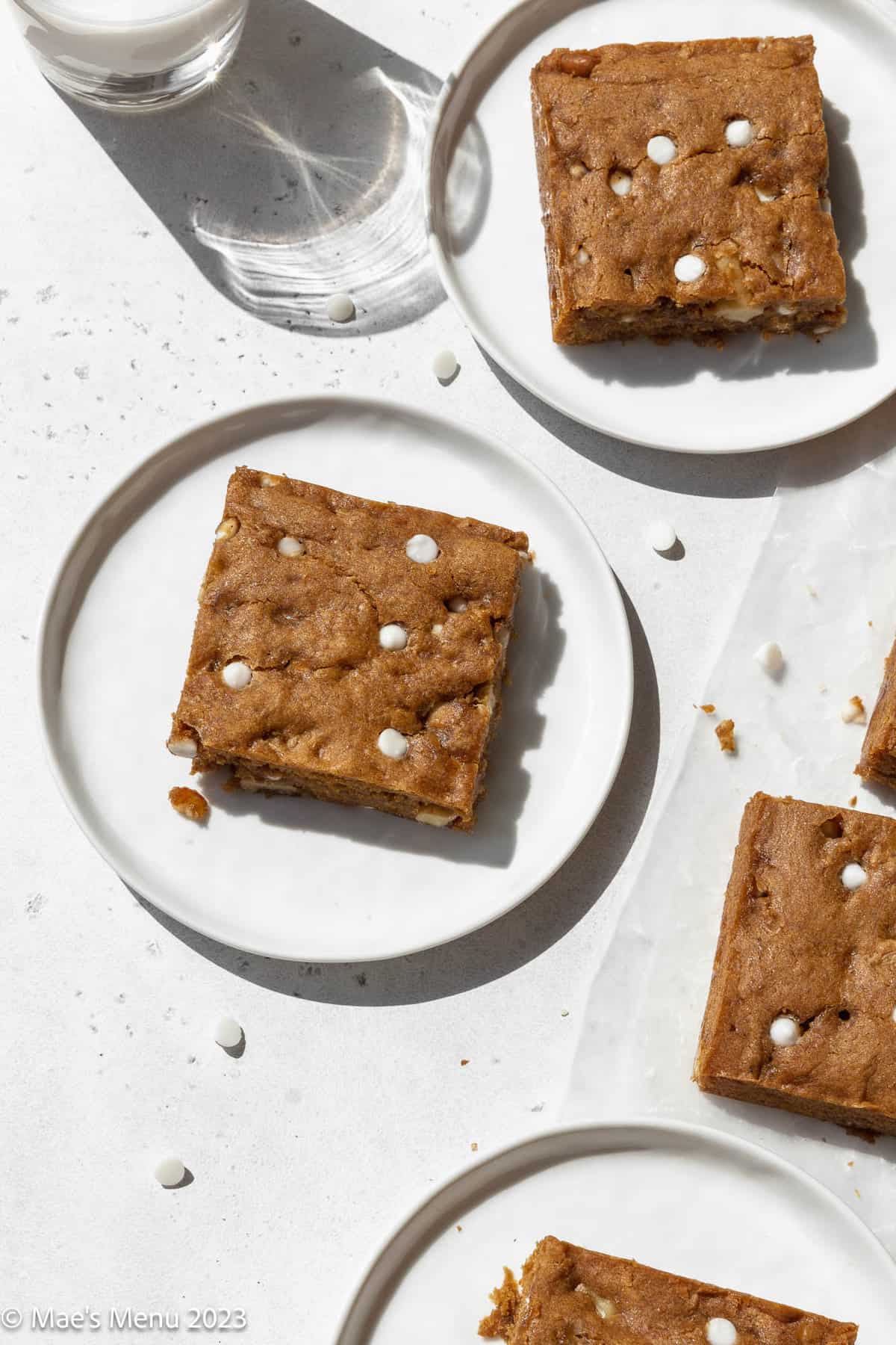 vegan blondies on white dishes and parchment paper.