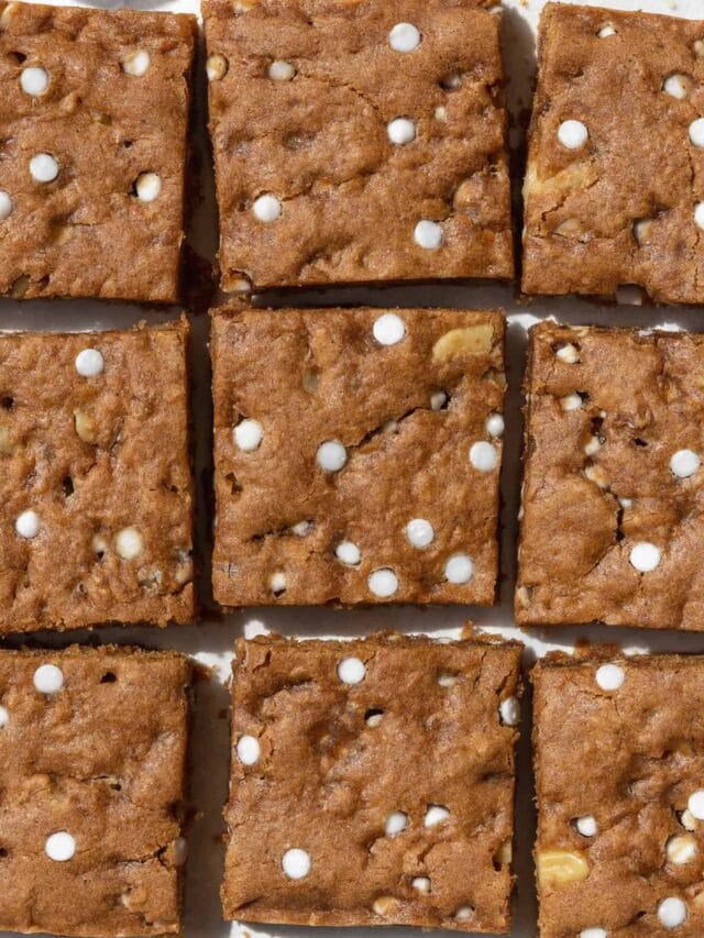 An overhead shot of cut up vegan blondies on white parchment paper.