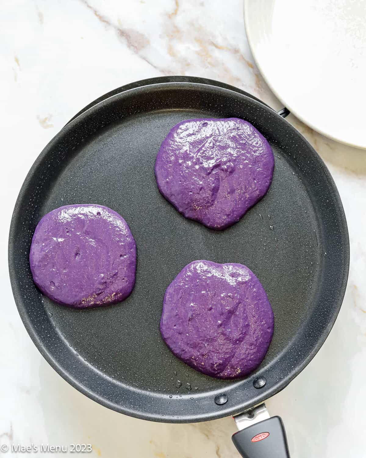 Cooking the ube pancakes on a griddle.