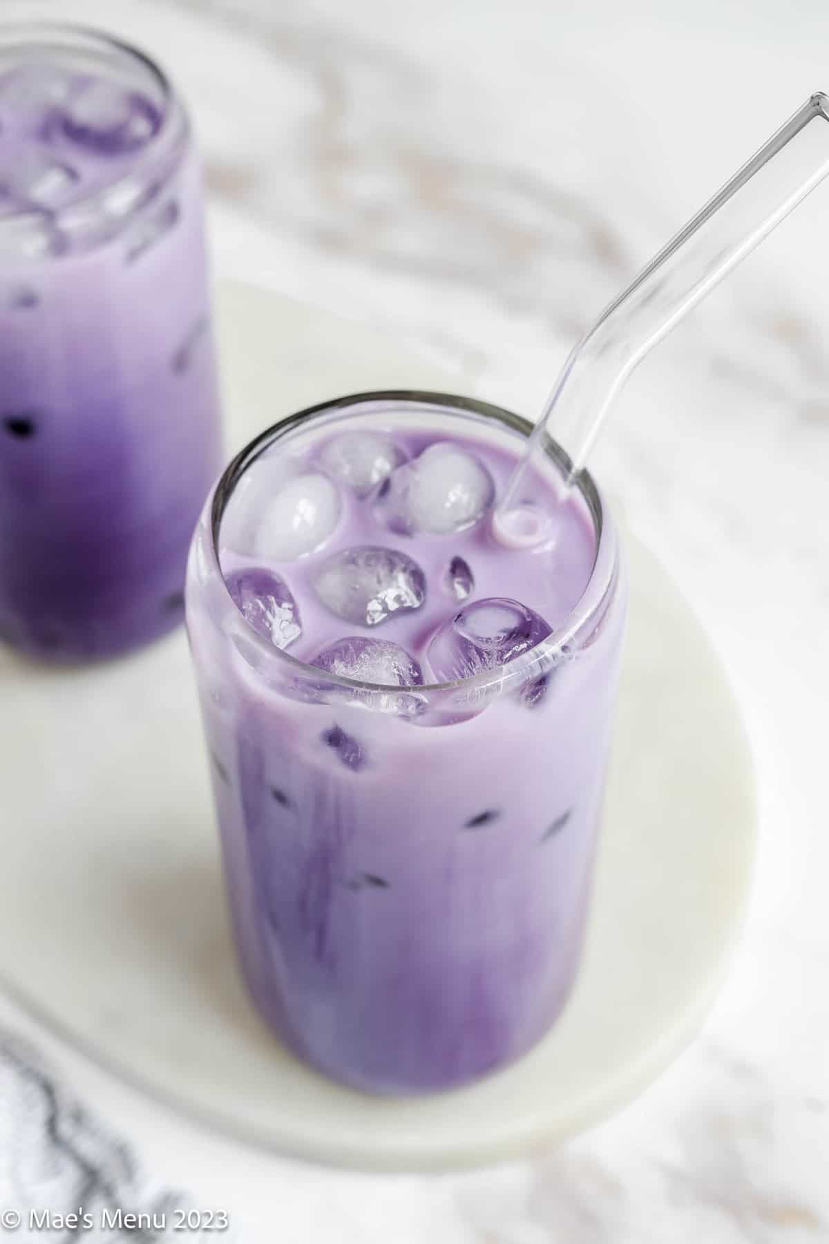 An overhead shot of a glass of ube boba with a clear straw.