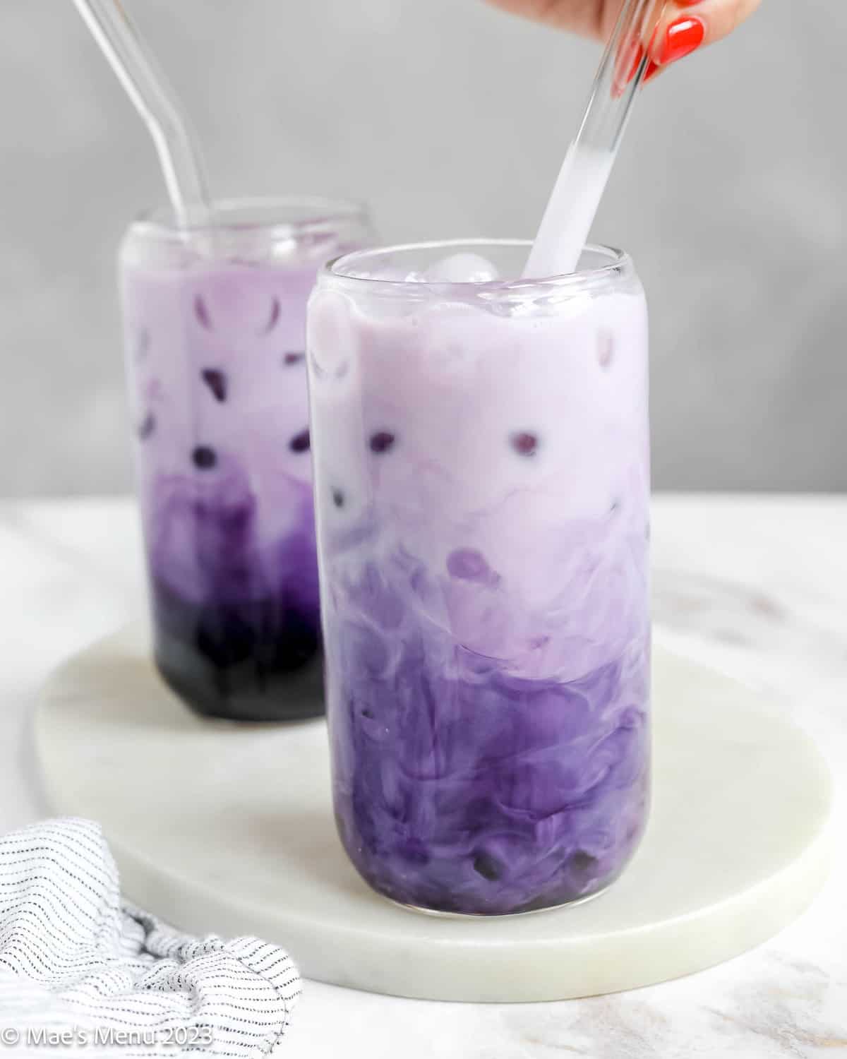 Stirring the ube boba with a clear straw.