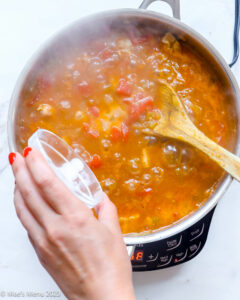 Pouring the cornstarch slurry into the pot of green chili.