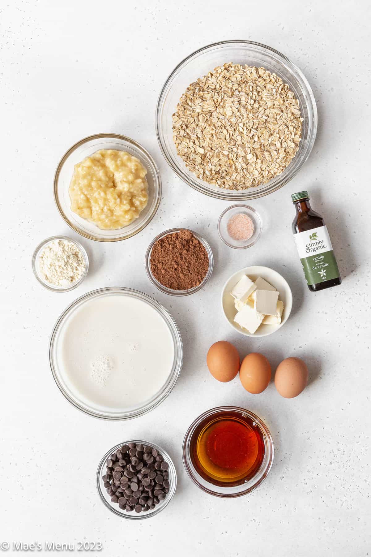 All of the ingredients for brownie baked oatmeal on a white counter.