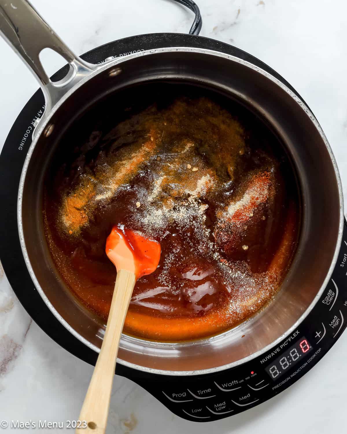 A sauce pan of BBQ sauce, honey, and seasonings.