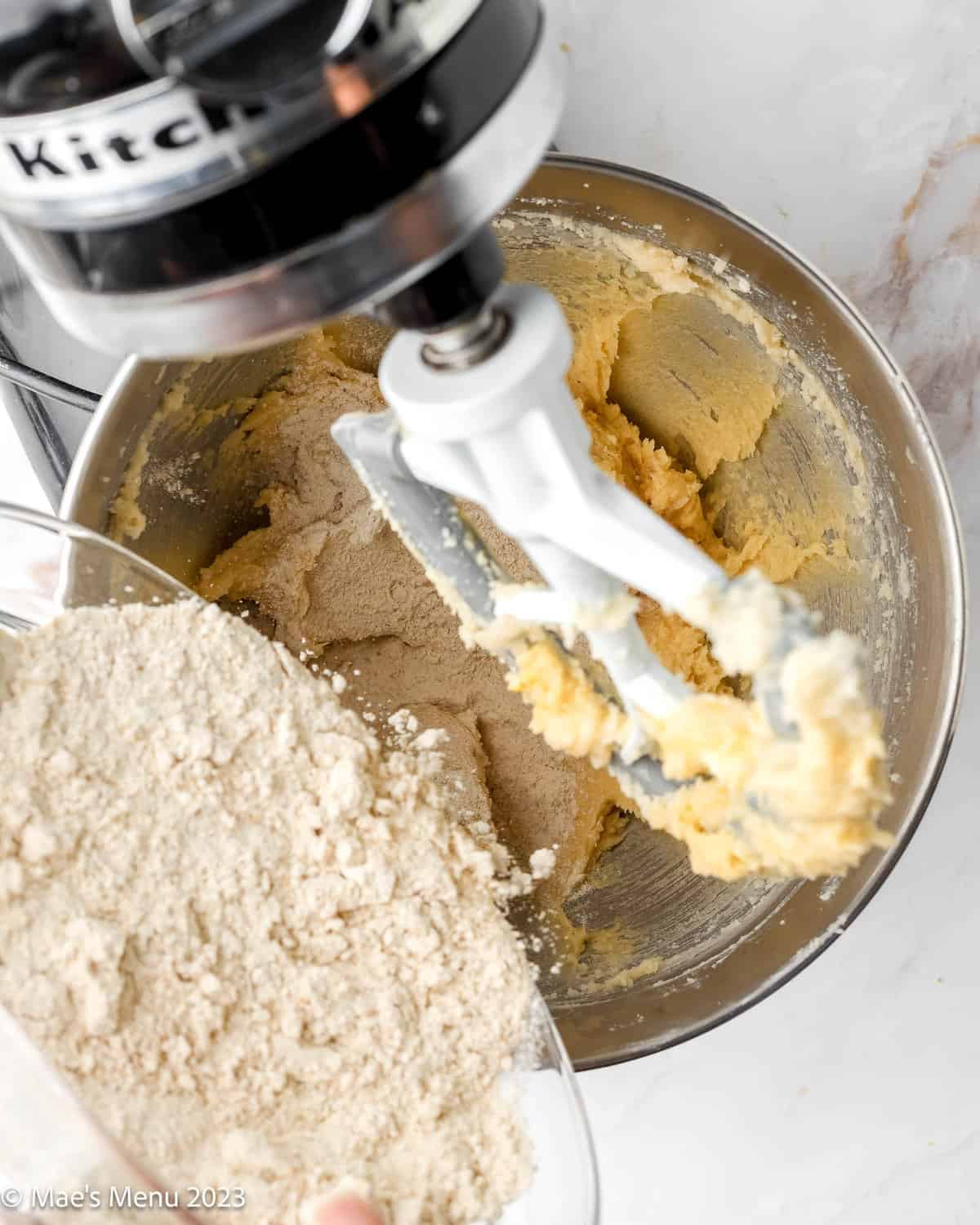 Adding flour to the creamed butter and sugar in the stand mixer.