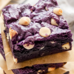 A pinterest pin for ube brownies with an angled shot of a stack of the brownies on the counter with parchment paper between them.