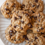 A pinterest pin for chewy oatmeal raisin chocolate chip cookies with an overhead shot of the cookies on a plate.