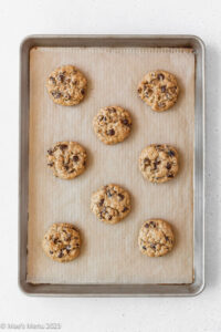 Oatmeal raisin chocolate chip cookies on a cookie sheet over coming out of the oven.
