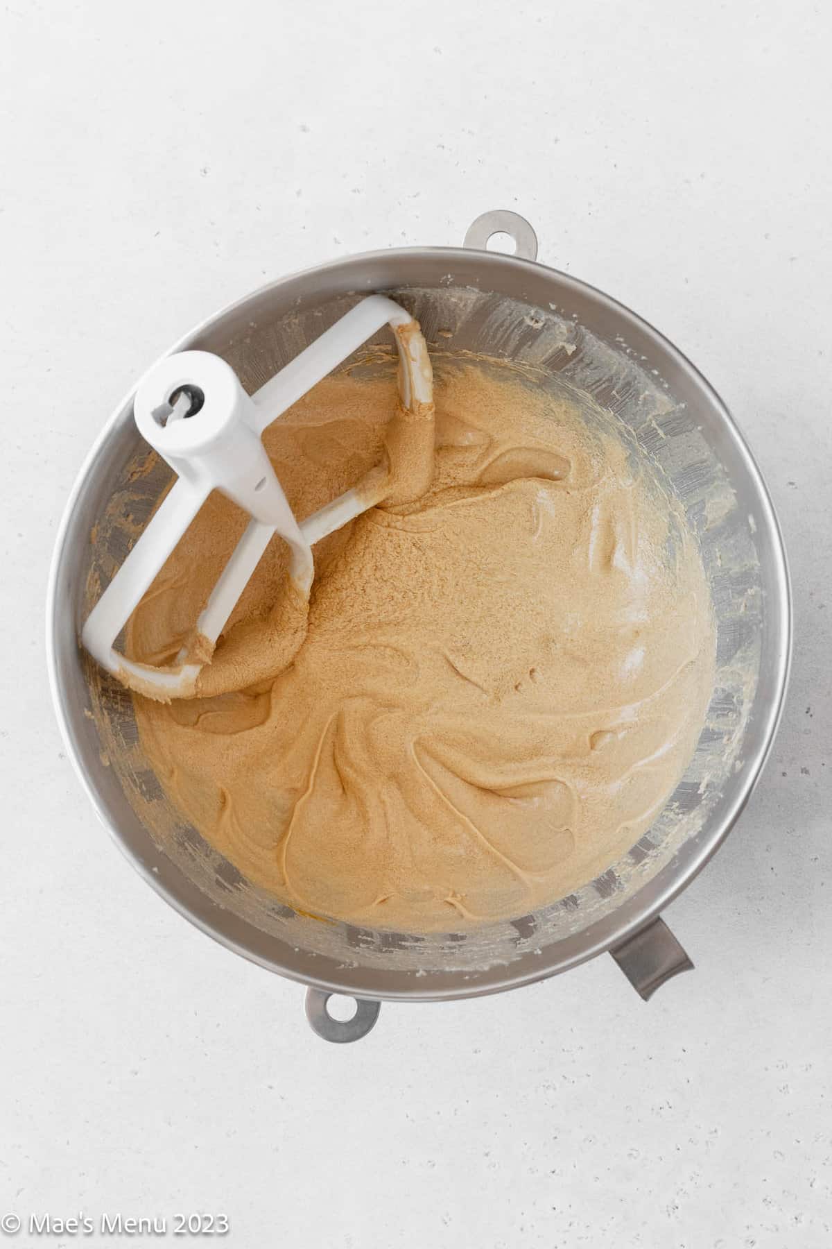 Creamed butter, sugar, and eggs in the bowl of a stand mixer with a mixing paddle.