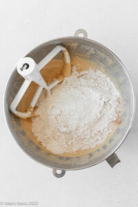Flour added to the creamed butter and sugar in the bowl of a stand mixer with the mixing paddle.
