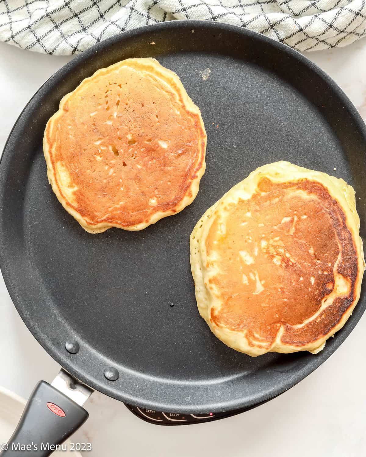 Cooking fluffy buttermilk pancakes on a griddle.