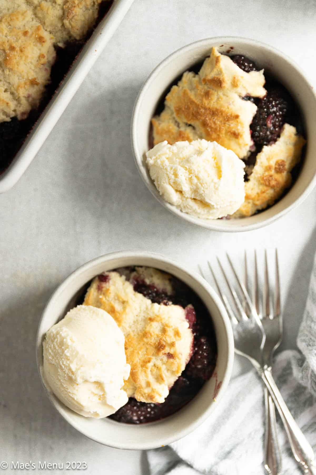An up-close overhead shot of two small dishes of gluten-free blackberry cobbler.