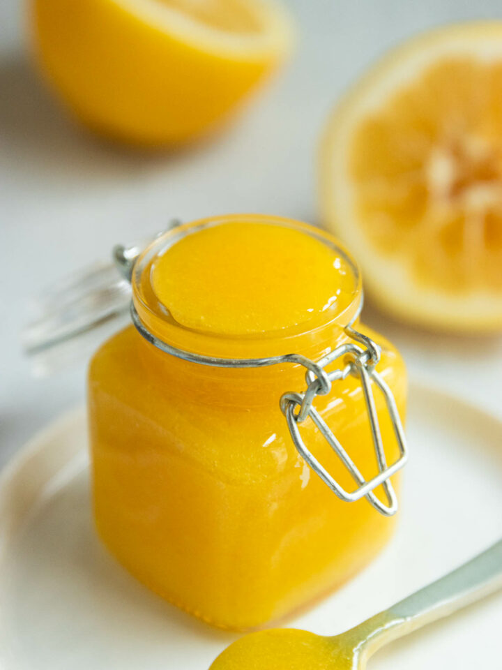 An up-close side shot of a small jar of meyer lemon curd.