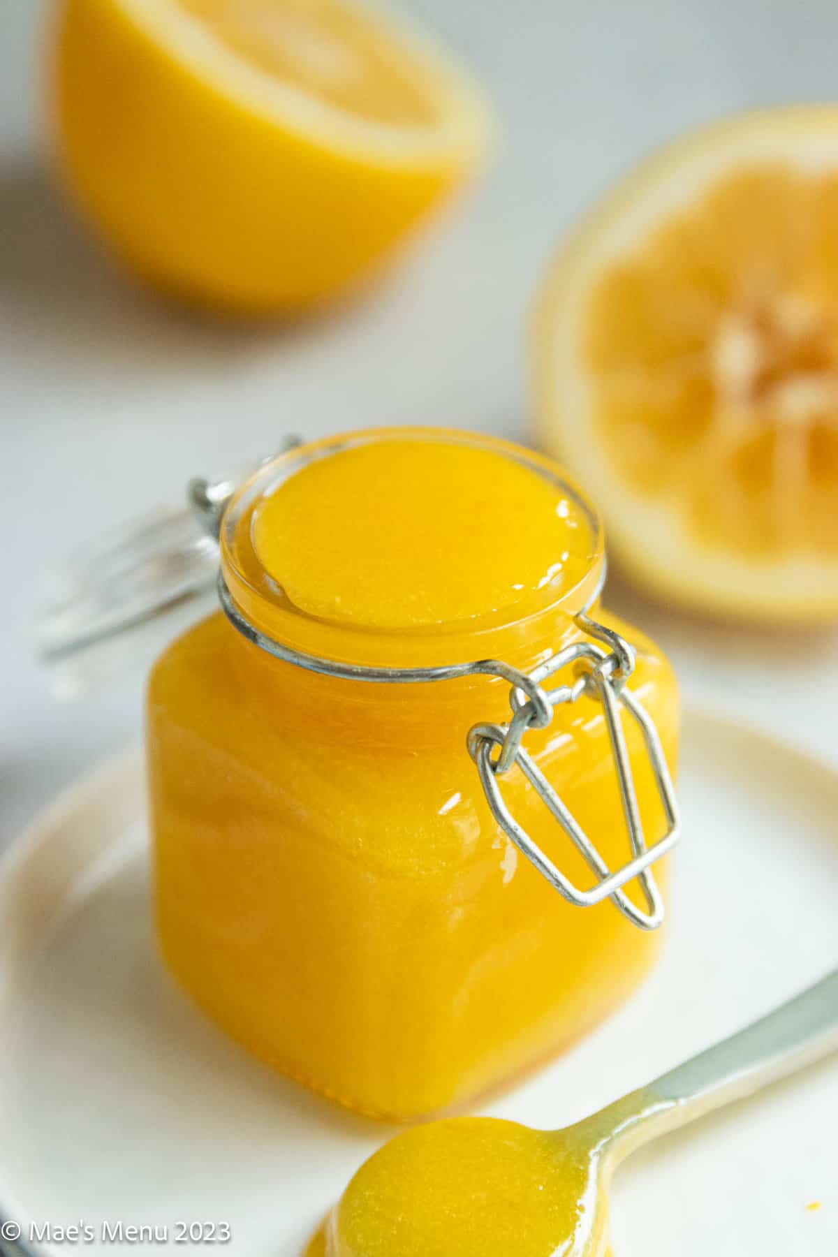 An up-close side shot of a small jar of meyer lemon curd.