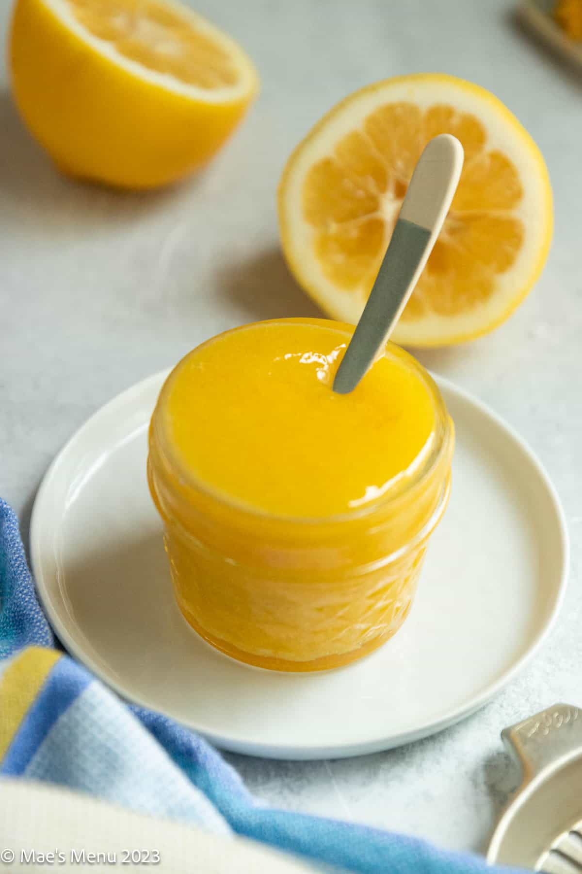 A small dish of meyer lemon curd with a spoon.
