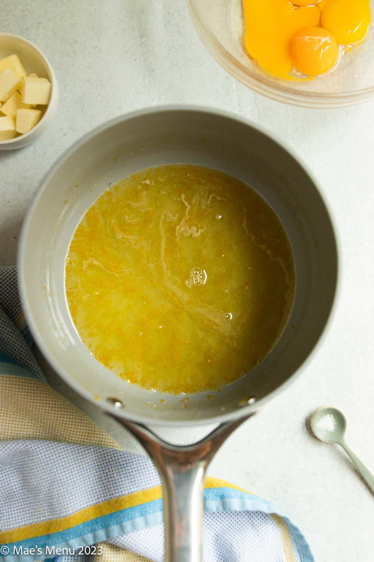 Sweetened lemon juice and curd in a saucepan.
