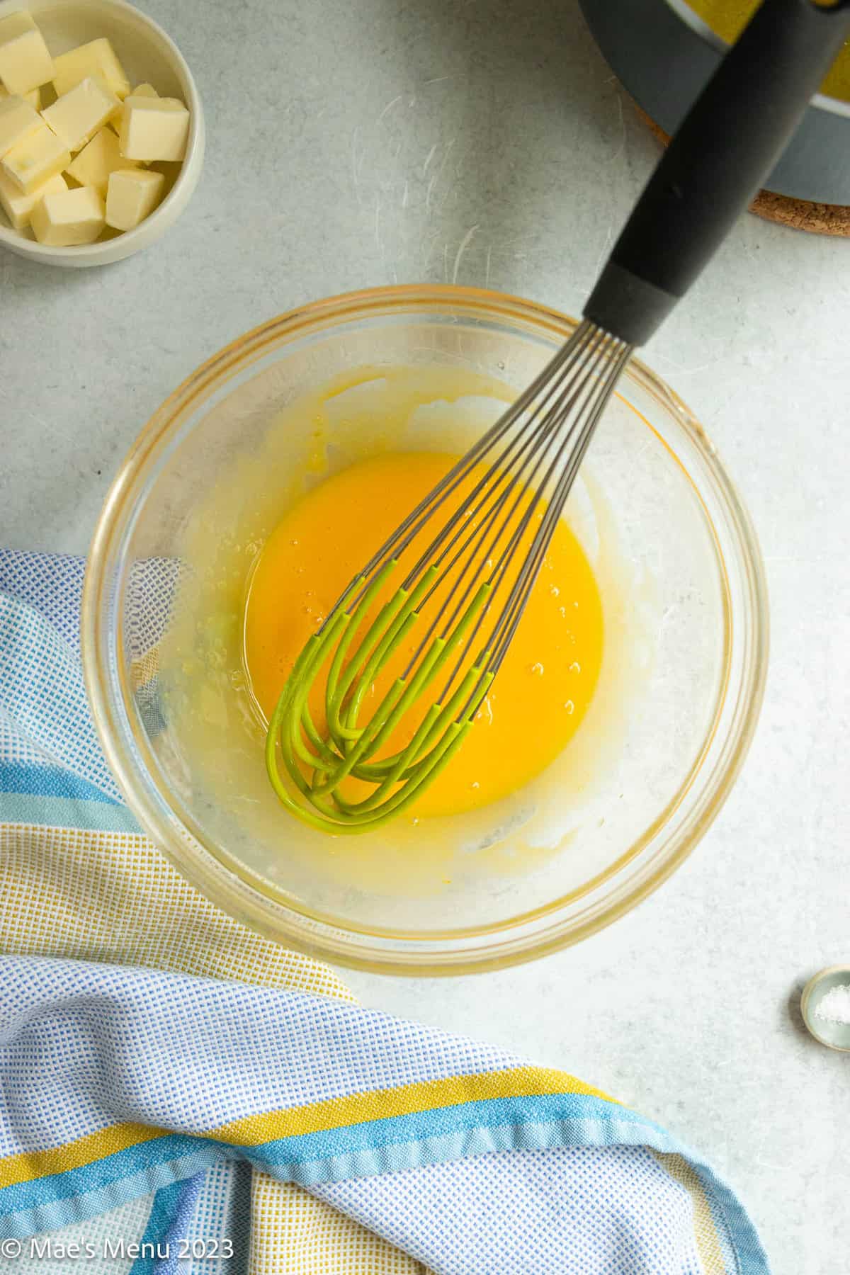 Whisked egg yolks in a glass bowl.